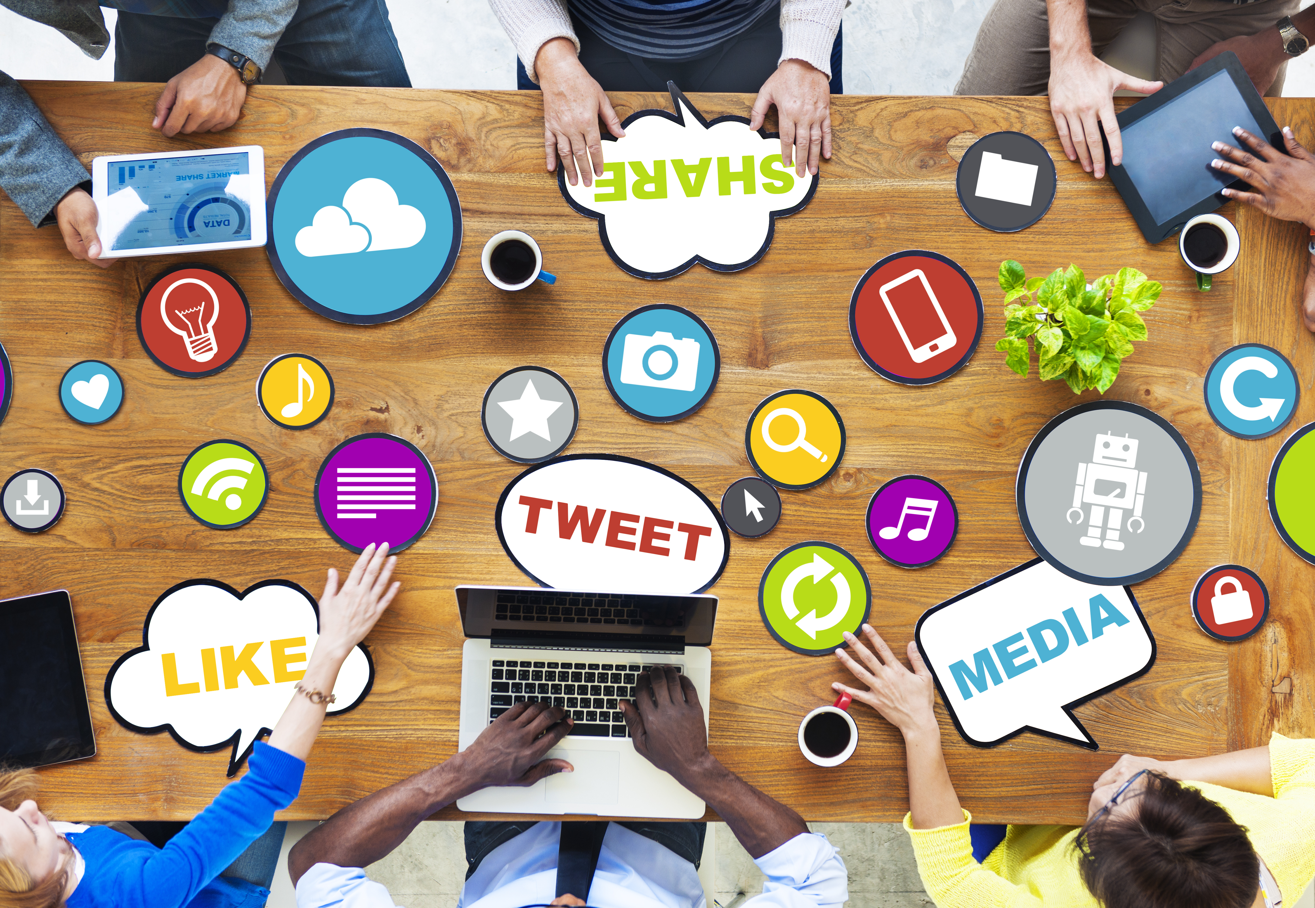 desk with a bunch of people around it and there's word bubbles that say stuff like LIKE and TWEET and SHARE and MEDIA